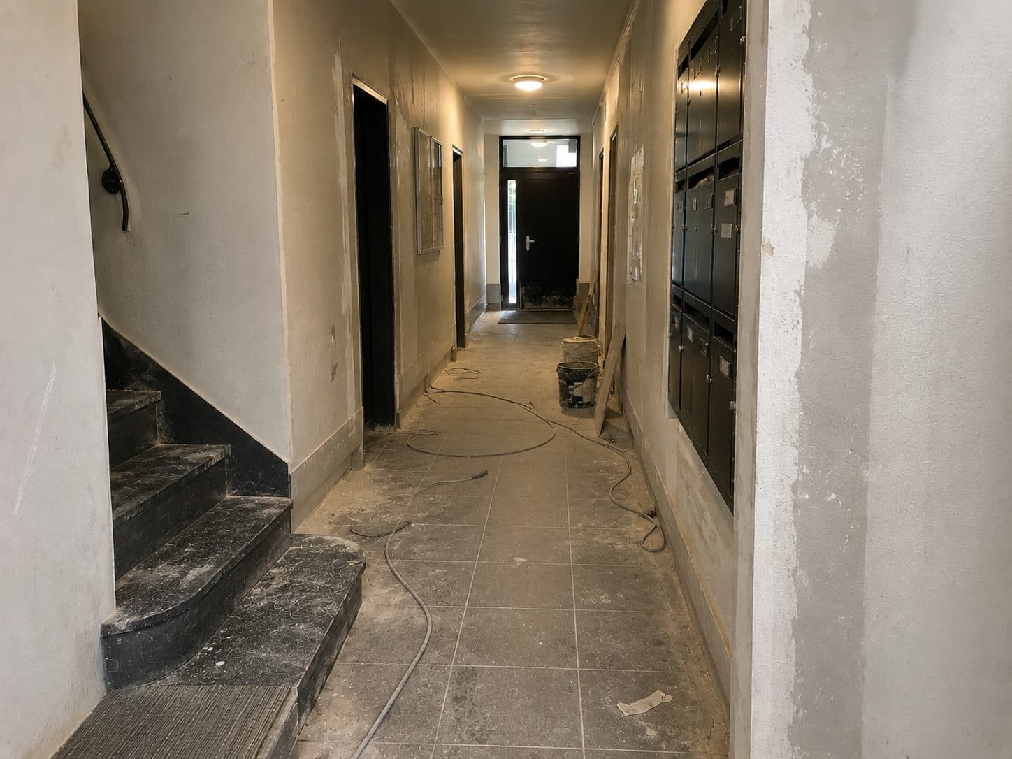 Couloir d'immeuble encombré avant remise en état