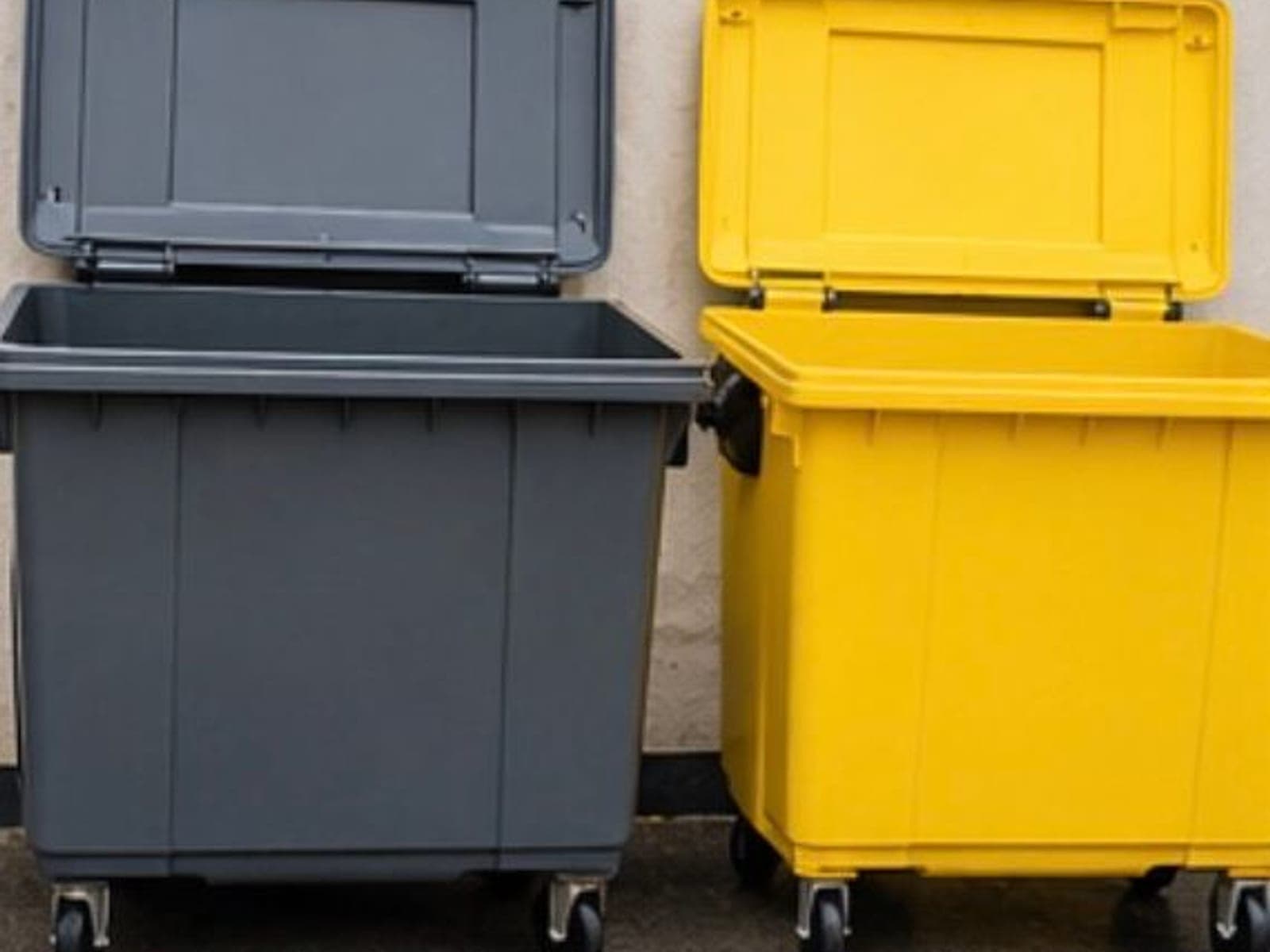 Clean grey and yellow wheelie bins after washing